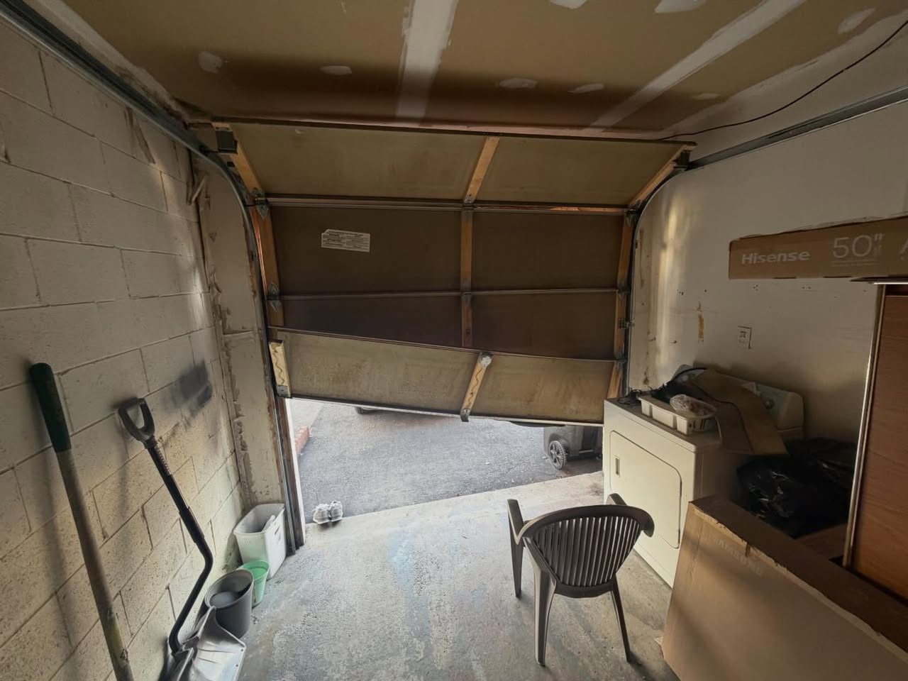 Inside view of a garage door with misaligned panels before repair