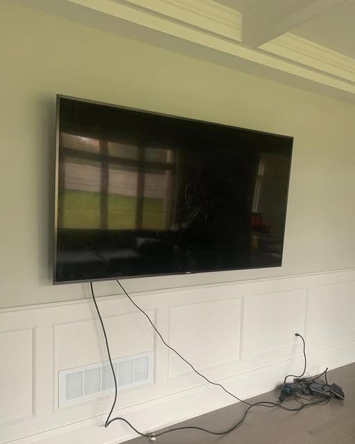 Large TV wall-mounted above wainscoting